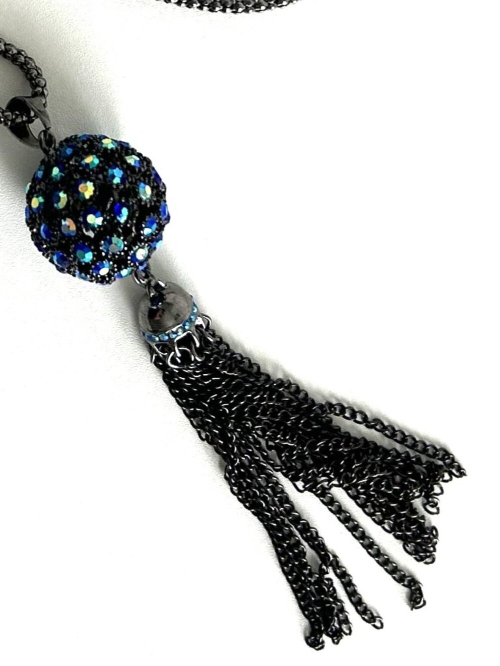 Metallic silver tone necklace features an unusual multi colored pendant